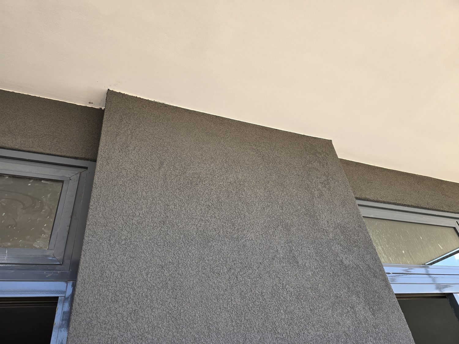 A rendered pier meeting the soffit. The texture reads consistently across a large flat area and dies cleanly into the change of plane — worth squinting at if you are judging whether an EIFS finish will look flat or patchy from the street.