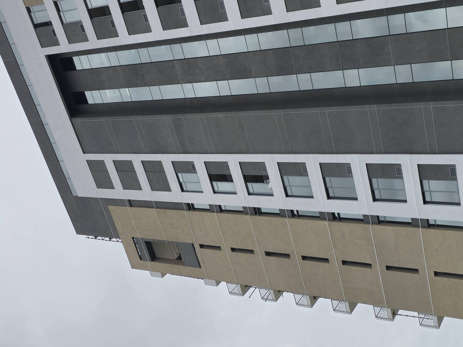 Full-height elevation, complete. Colour bands, punched openings, recessed shadow gaps and projecting frames all delivered in the same single render system across the whole building.