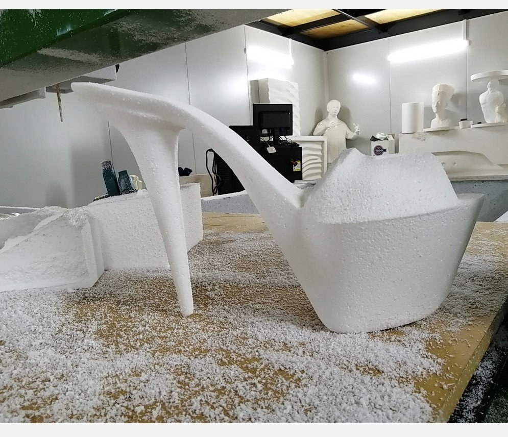 Large stiletto shoe carved from an EPS block, unpainted surface, workshop setting