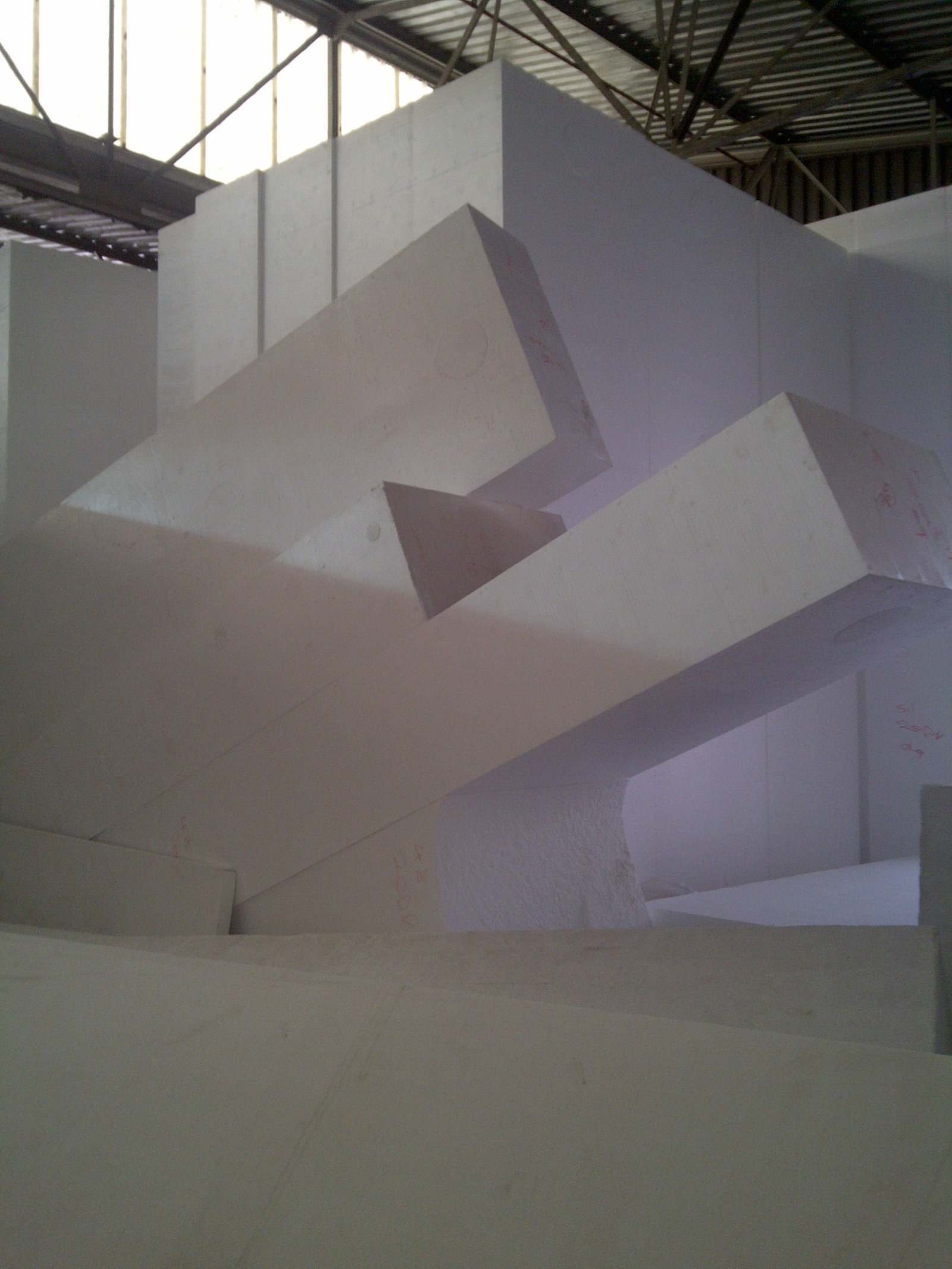 Large angular, faceted EPS sculptural form marked with red reference numbers, stacked against warehouse stock