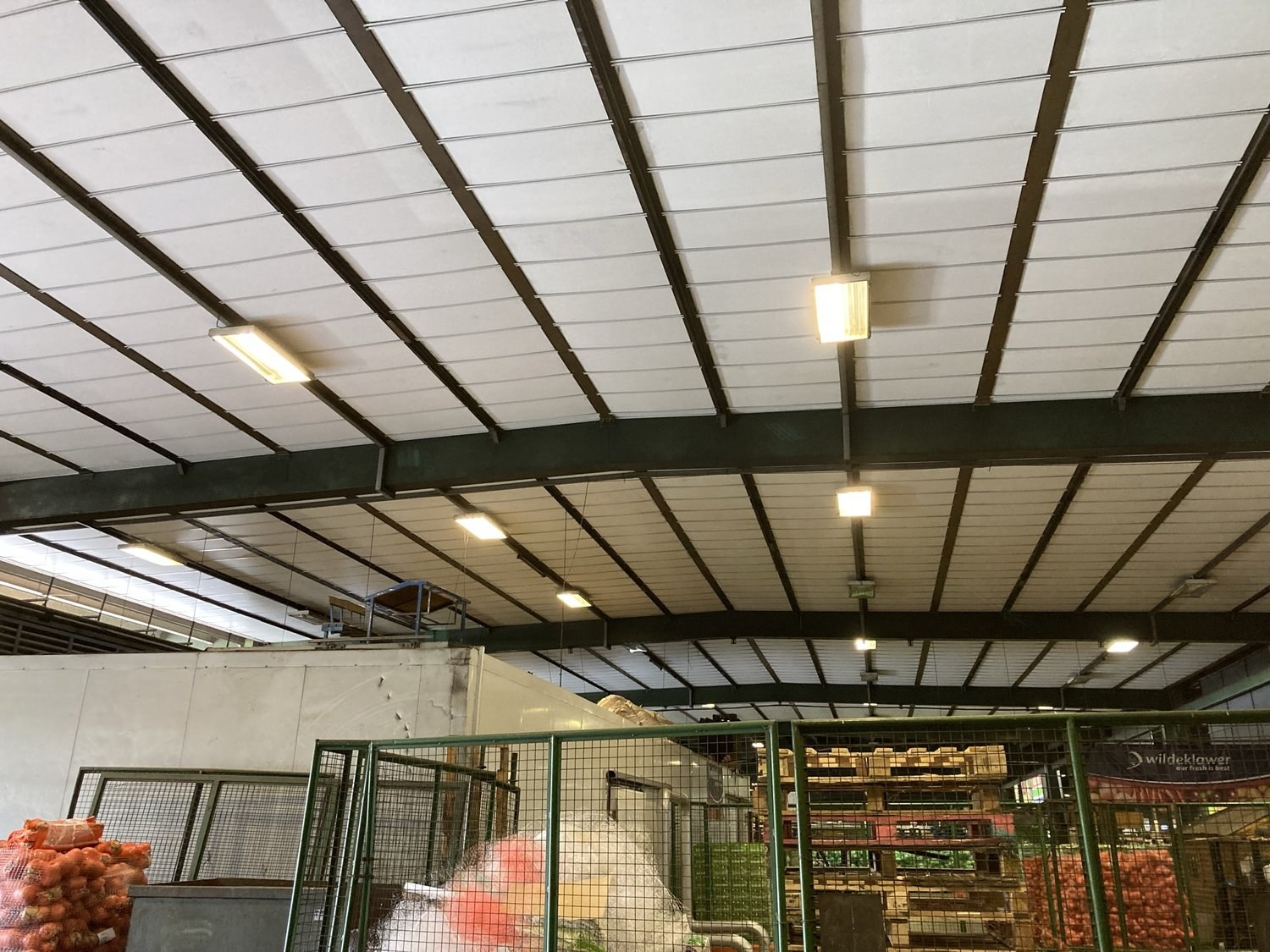 Insulated ceiling boards fitted across steel roof trusses in a fresh-produce market hall