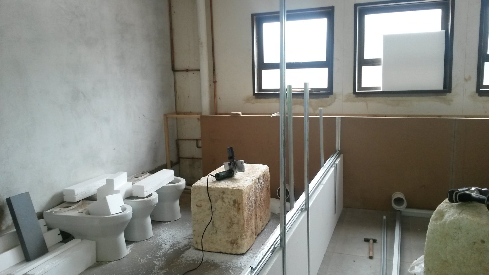 EPS board cut to size stacked beside toilet pans during a bathroom fitout