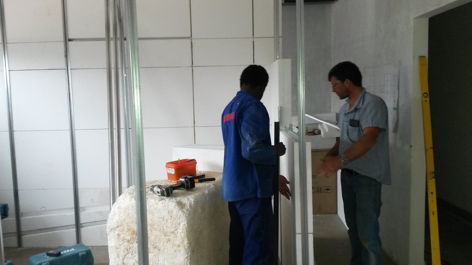 Two installers fitting a door frame into an EPS panel wall