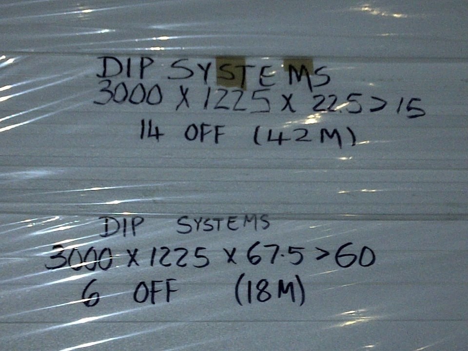 Handwritten order specification taped to a wrapped EPS board bundle