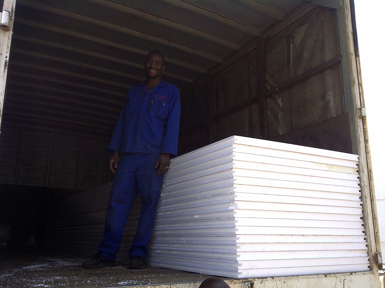 Worker beside a stack of EPS boards loaded in a truck