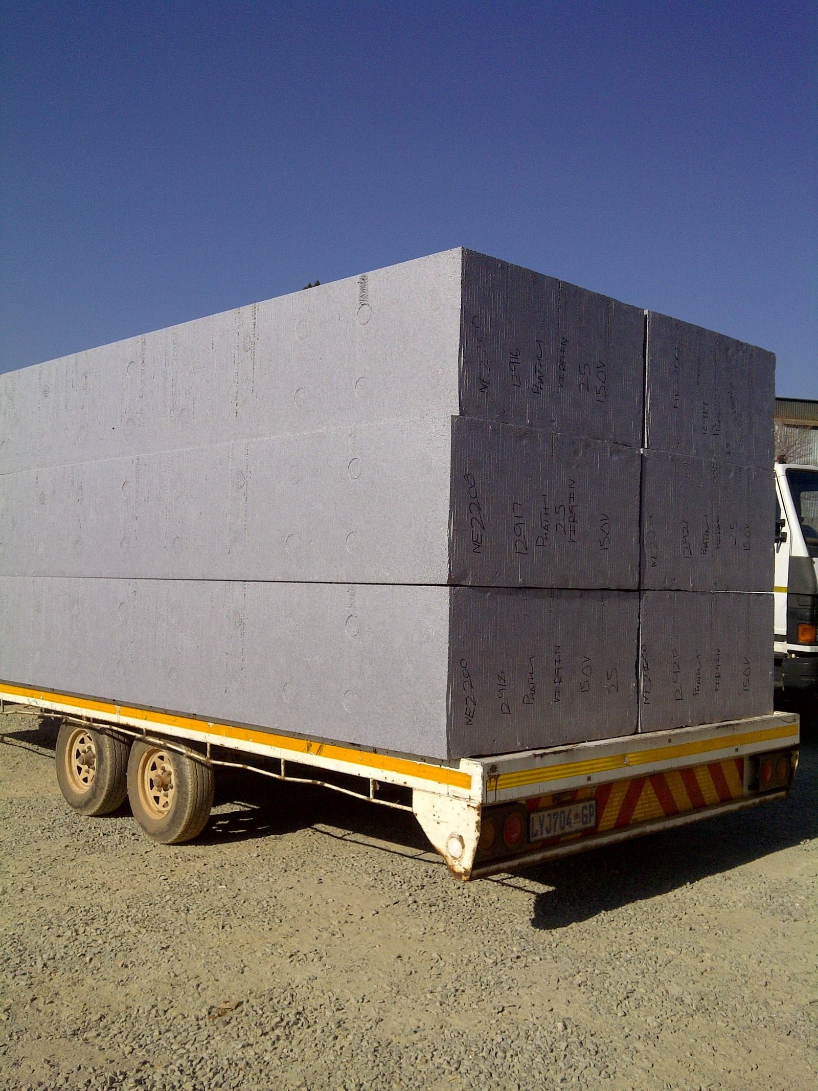 EPS blocks marked with grade and order details, loaded on a delivery trailer