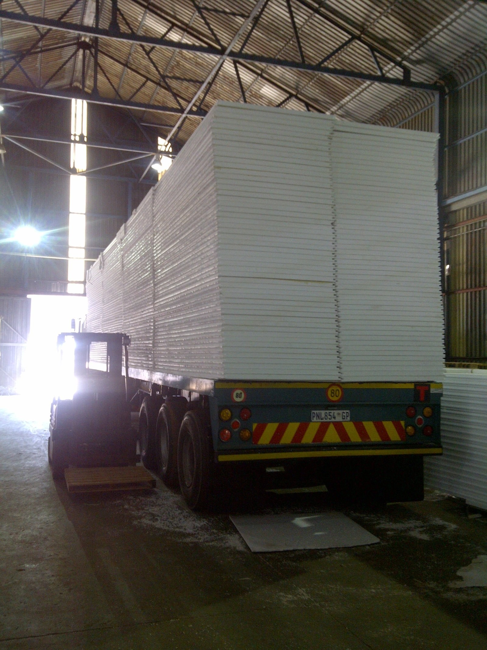 Flatbed trailer loaded with EPS panels inside the warehouse
