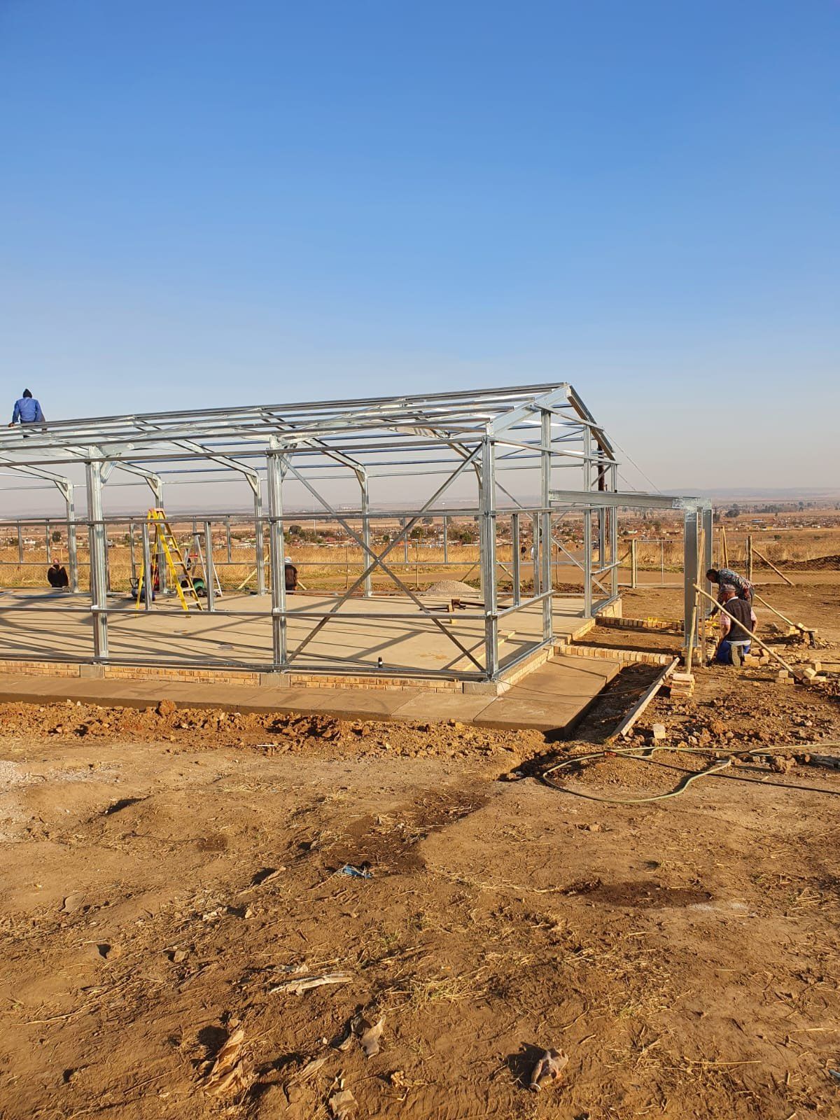 Steel columns and roof purlins supporting the sheeted roof over an open-sided structure