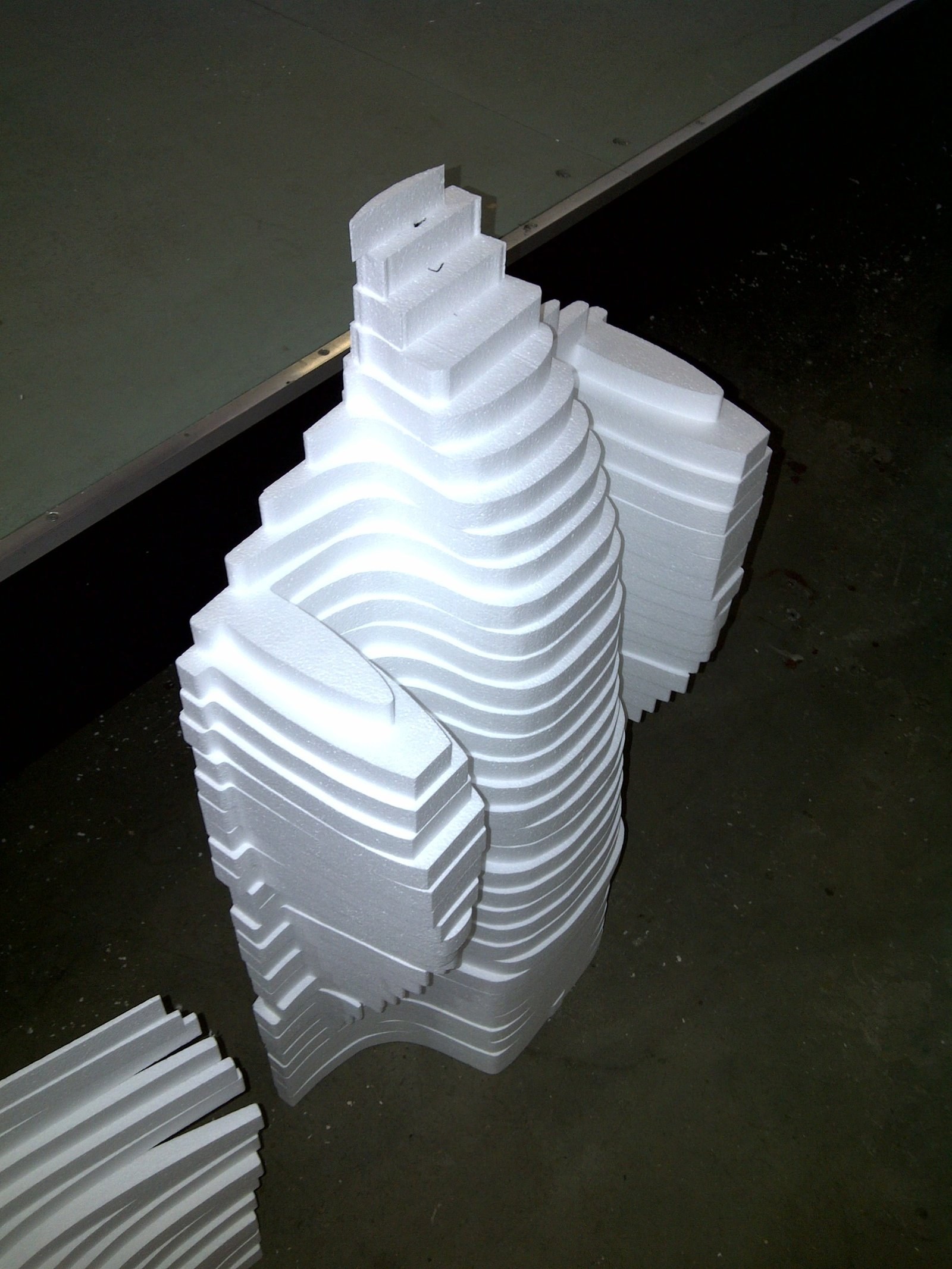 Stack of cut stepped, curved cornice moulding profiles set on the factory floor