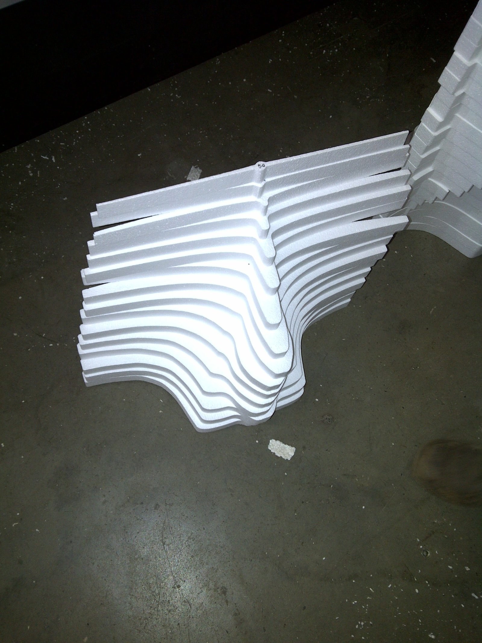 Stack of cut wavy ribbed cornice moulding profiles set on the factory floor