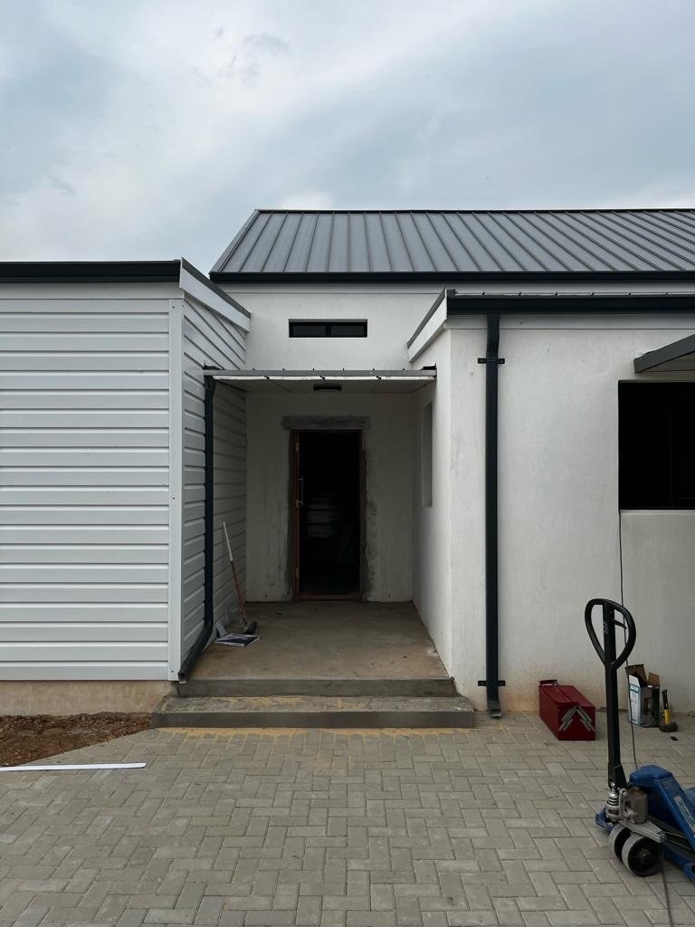 Finished house entrance porch with a steel-clad gable end and standing-seam roof alongside