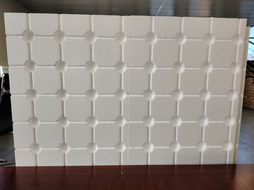 The board face, showing the moulded dimple grid that holds it off the inner leaf and keeps the drainage path in the cavity clear.