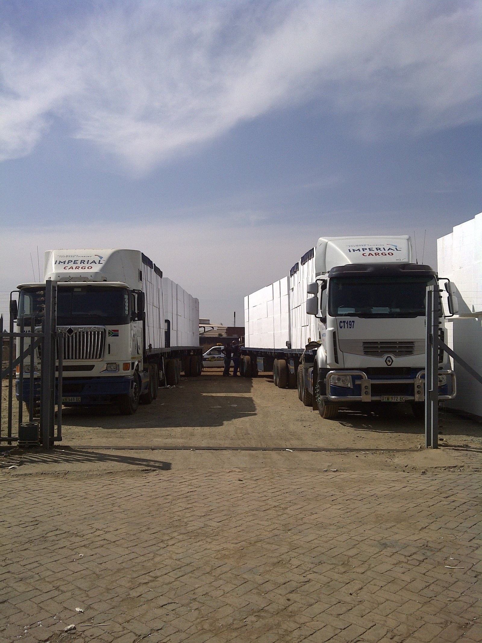 Two flatbed trucks loaded with panels for delivery to site