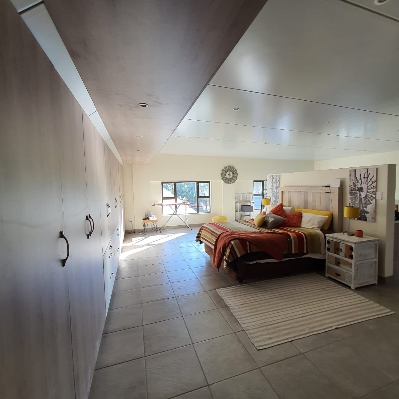 Panel ceiling with a bulkhead step above a fitted wardrobe wall in a bedroom