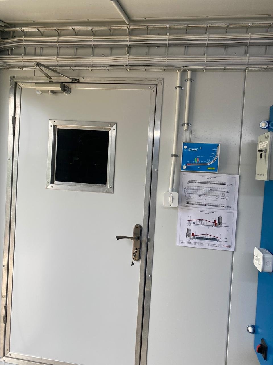 Interior door in a panel wall with cable tray and climate controller mounted alongside