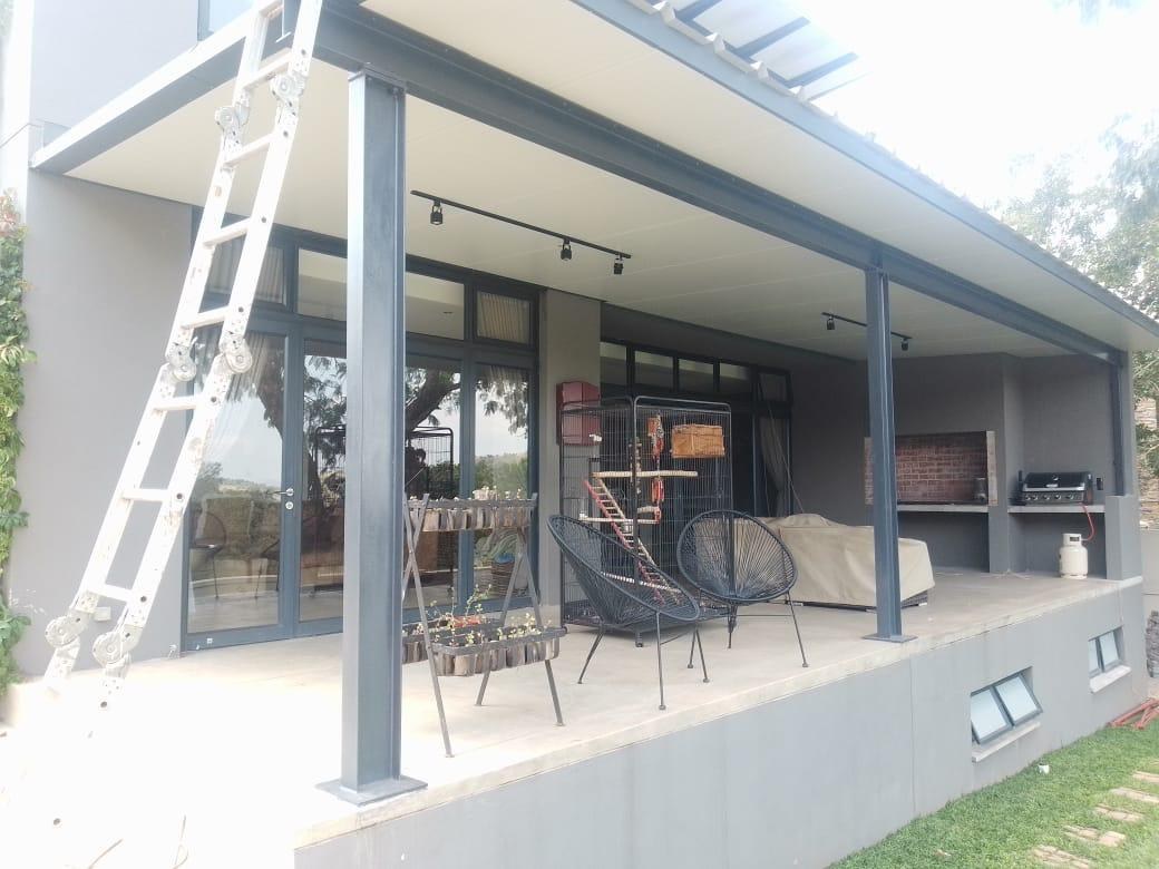 Flat LiteSpan panel patio canopy on steel posts, finished white underside spanning the full porch