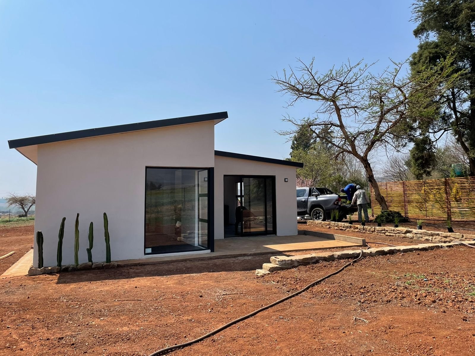 Completed skillion-roof house with standing-seam roof sheeting, dry landscaping and a cactus bed in front