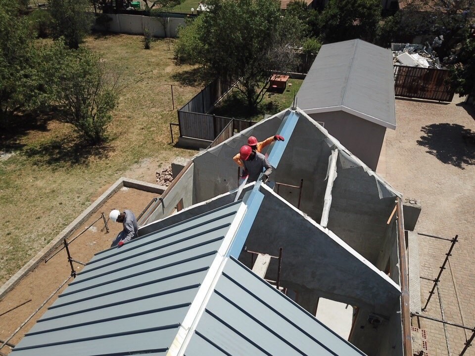 Aerial view of ridge flashing being fitted where two roof pitches meet