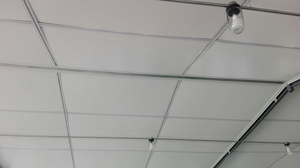 Close-up of ceiling panel joints with light fittings mounted along the seams