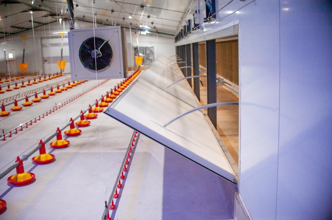 Interior view of an open air-inlet damper in an insulated wall panel, feeder lines below