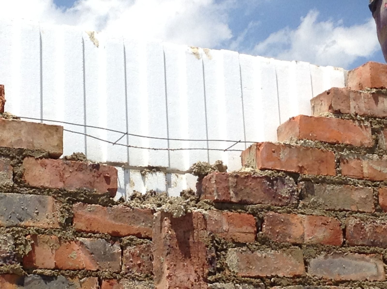 Wire wall tie over an EPS cavity board, closeup