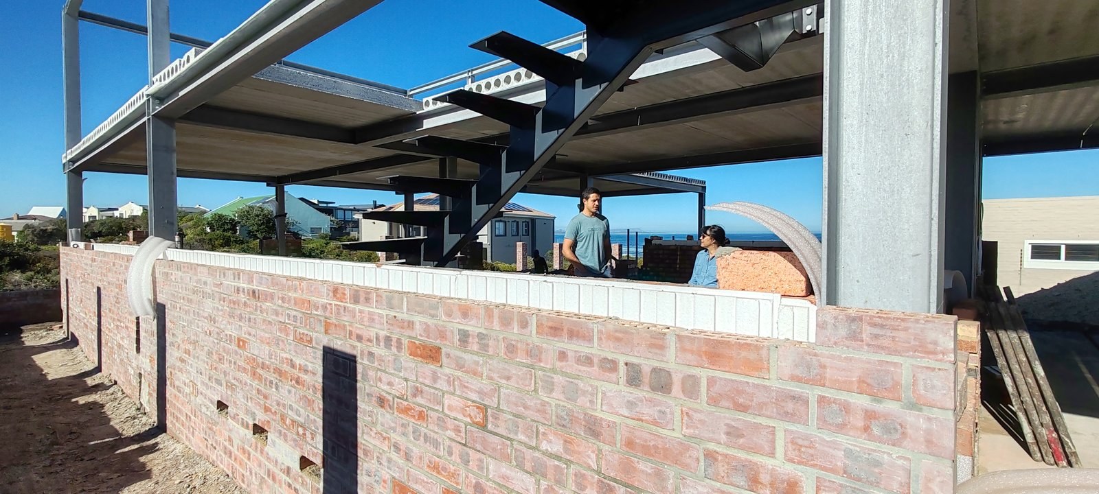 Insulated brick parapet wall under a steel floor structure, coastal site