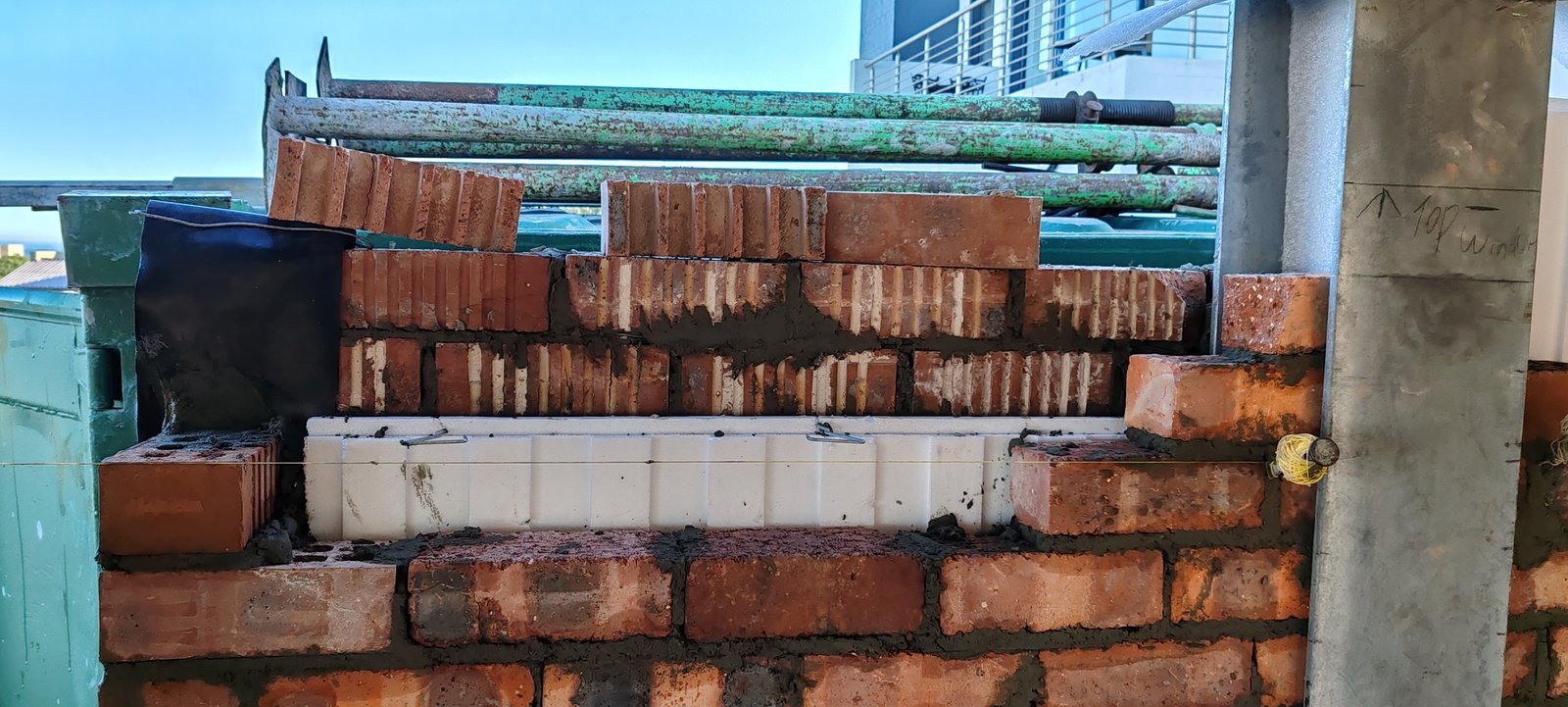Cavity board fitted above a lintel, "top window" marked on the steel column