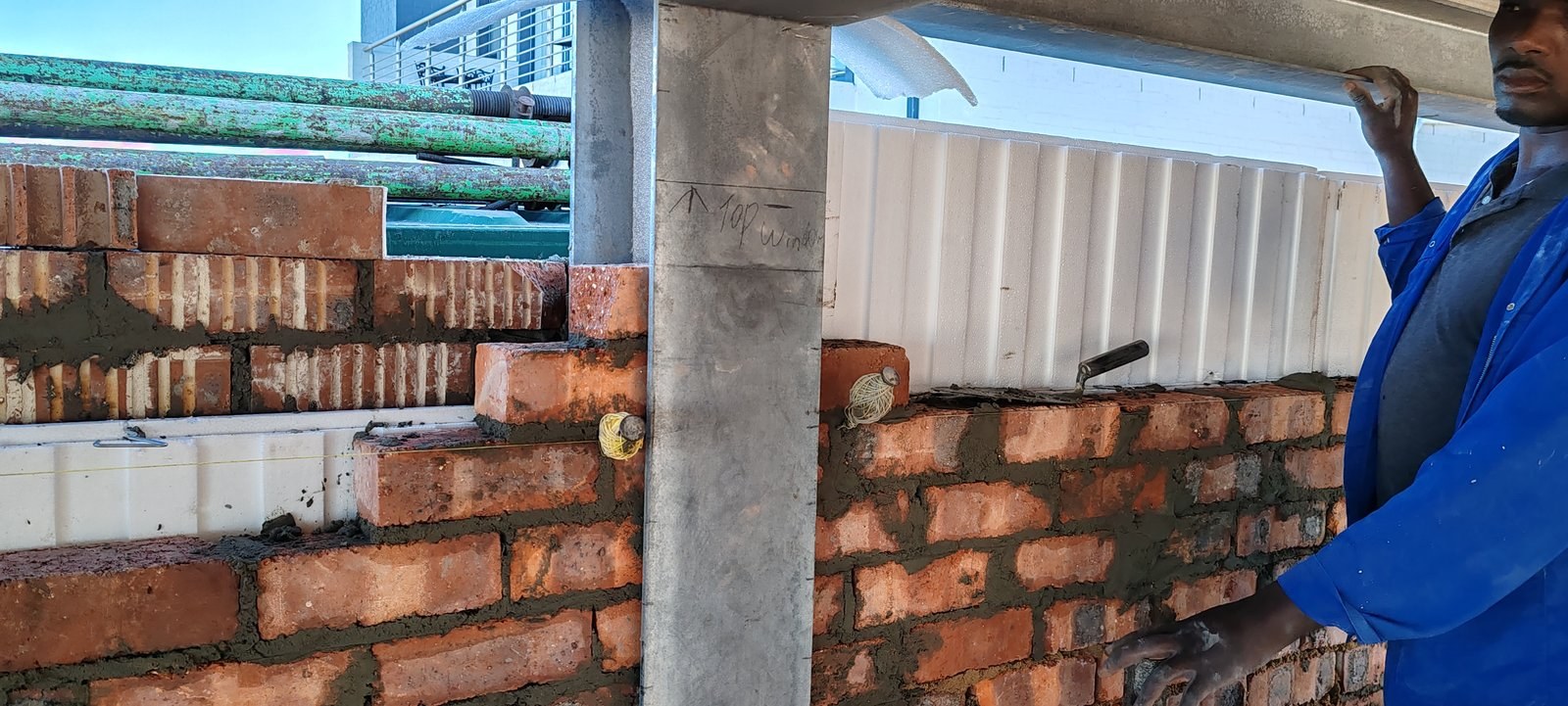 Positioning a cavity board over a lintel marked "top window"