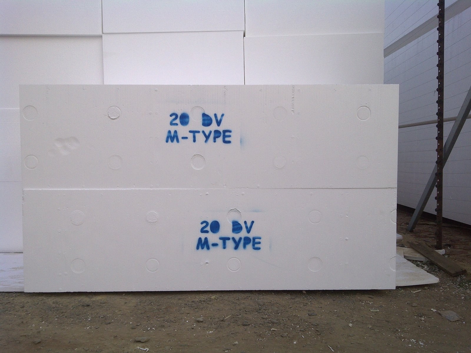 20 DV M-Type void former blocks stacked in front of a building, dusk light