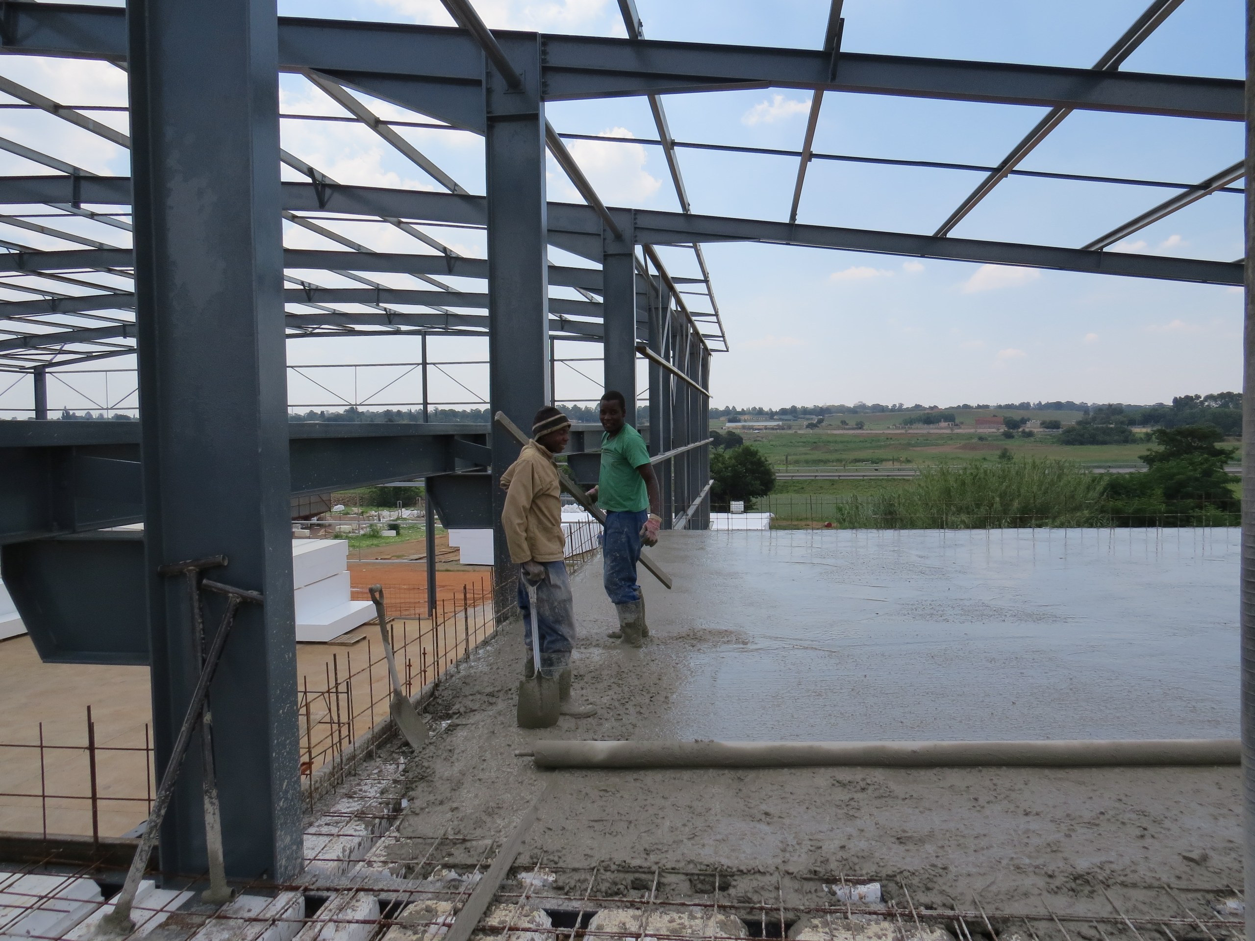 Placing the concrete topping over the void-former deck on the elevated floor. Only the ribs and the topping take concrete, so the slab is markedly lighter than a solid one of the same span.