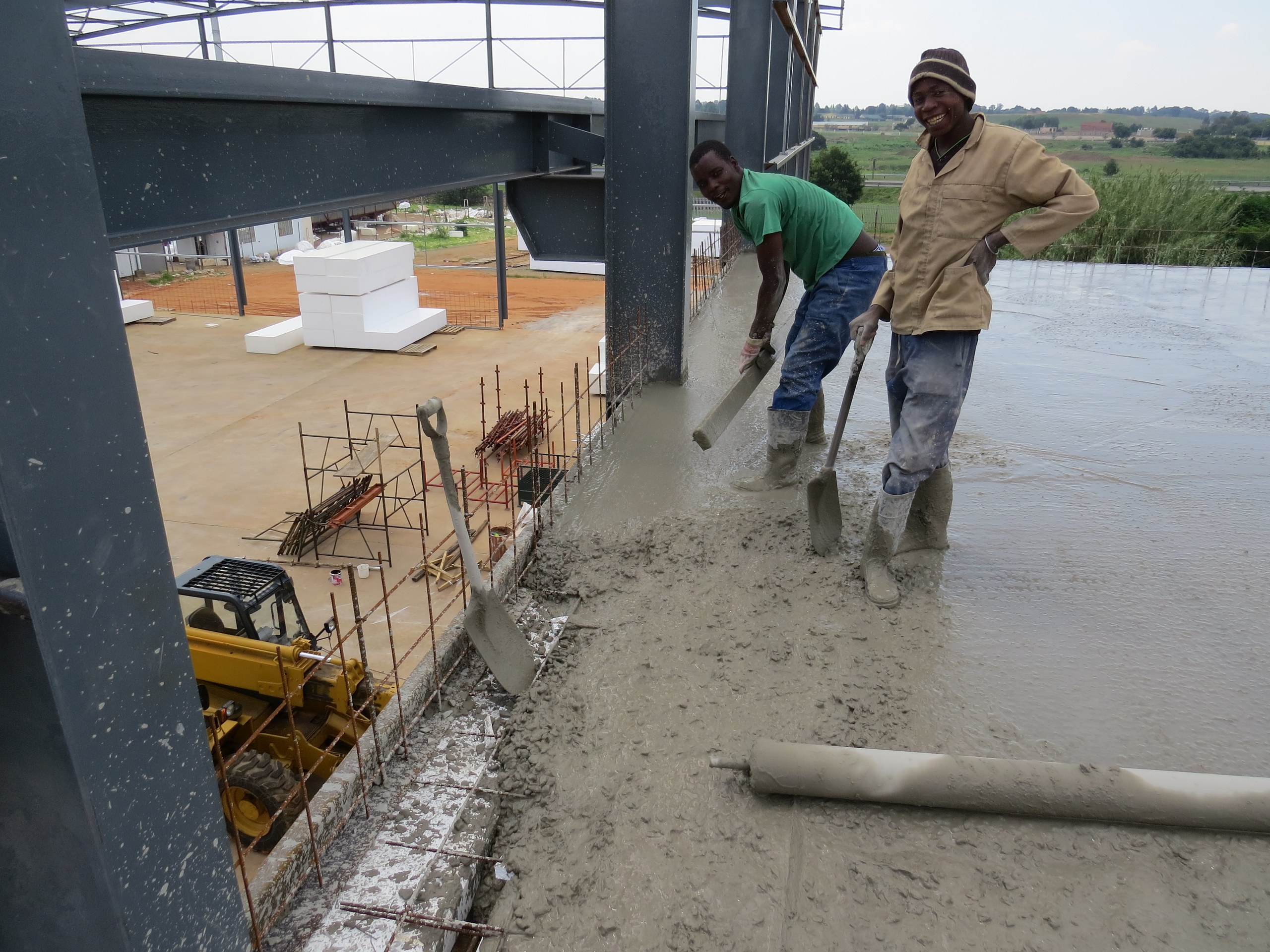 Screeding the fresh concrete flat over the void formers. Once cured, the blocks stay in place as permanent void formers inside the finished slab.