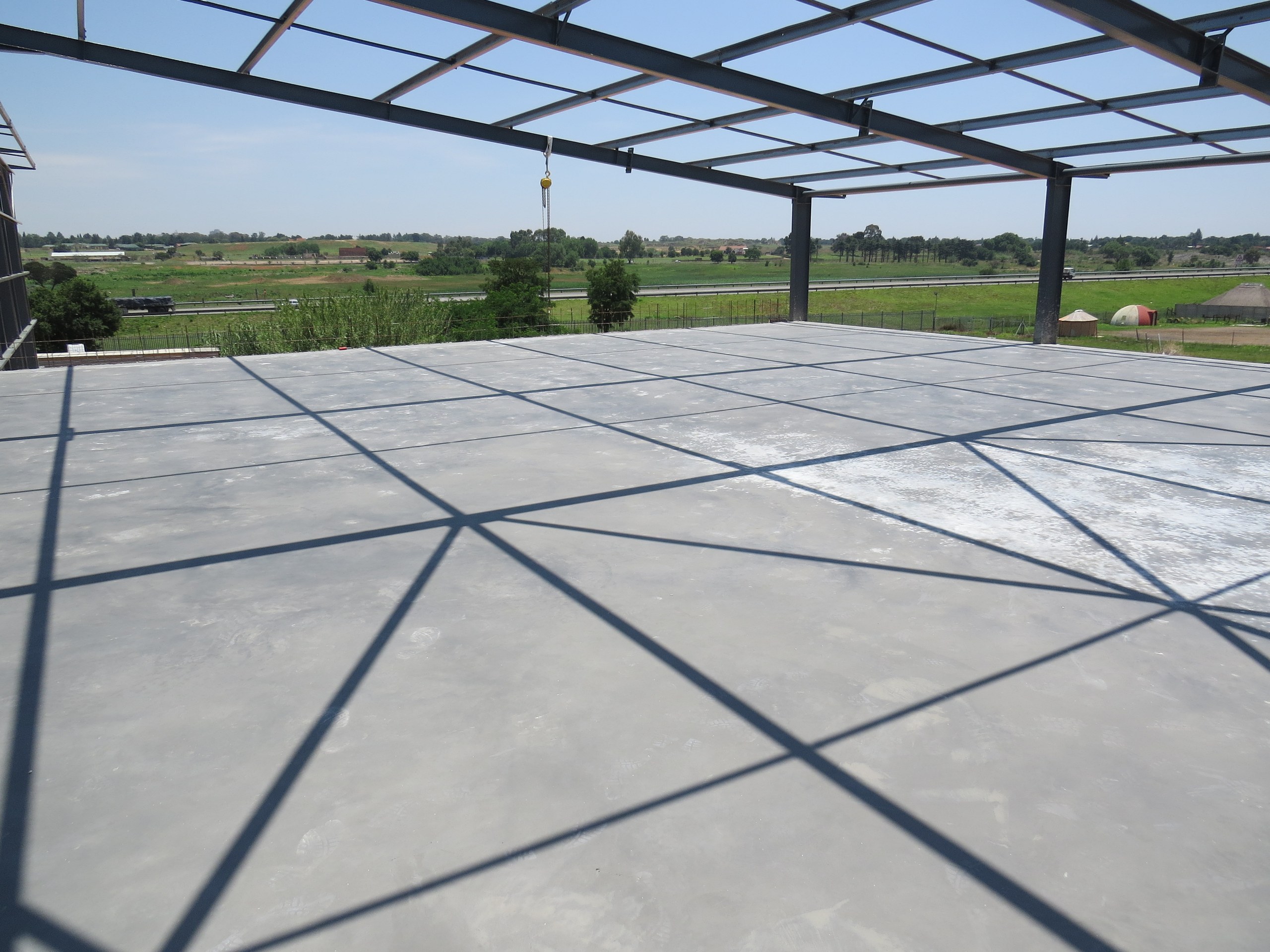 The finished suspended slab inside the steel portal frame, cast on the void formers and ready for the structure above.