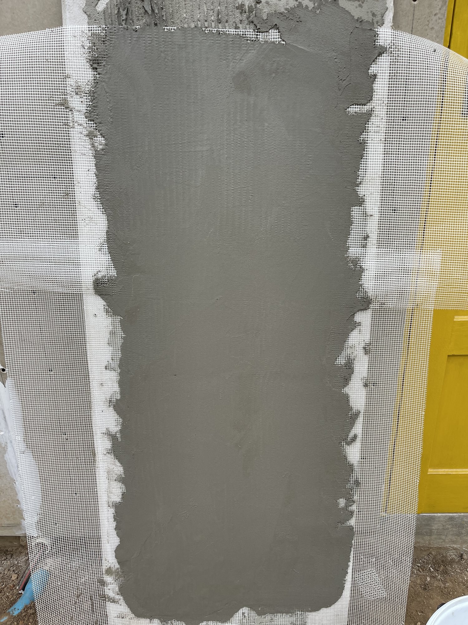Basecoat trowelled smooth over mesh at a wall corner