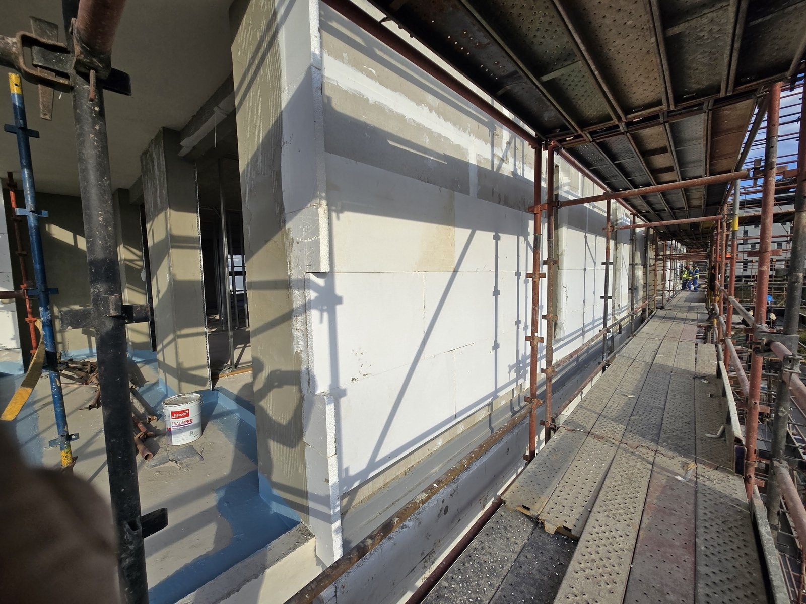 EPS-clad column ready for paint, tin of Plascon Tradepro on the scaffold deck