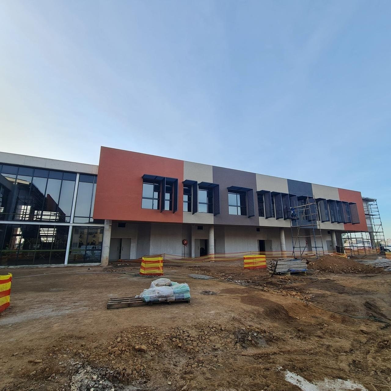Completed colour-banded render facade on a two-storey building